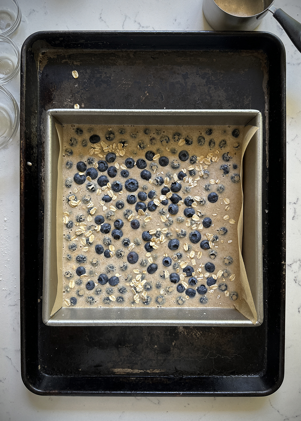 blueberry muffin baked oatmeal batter in square pan