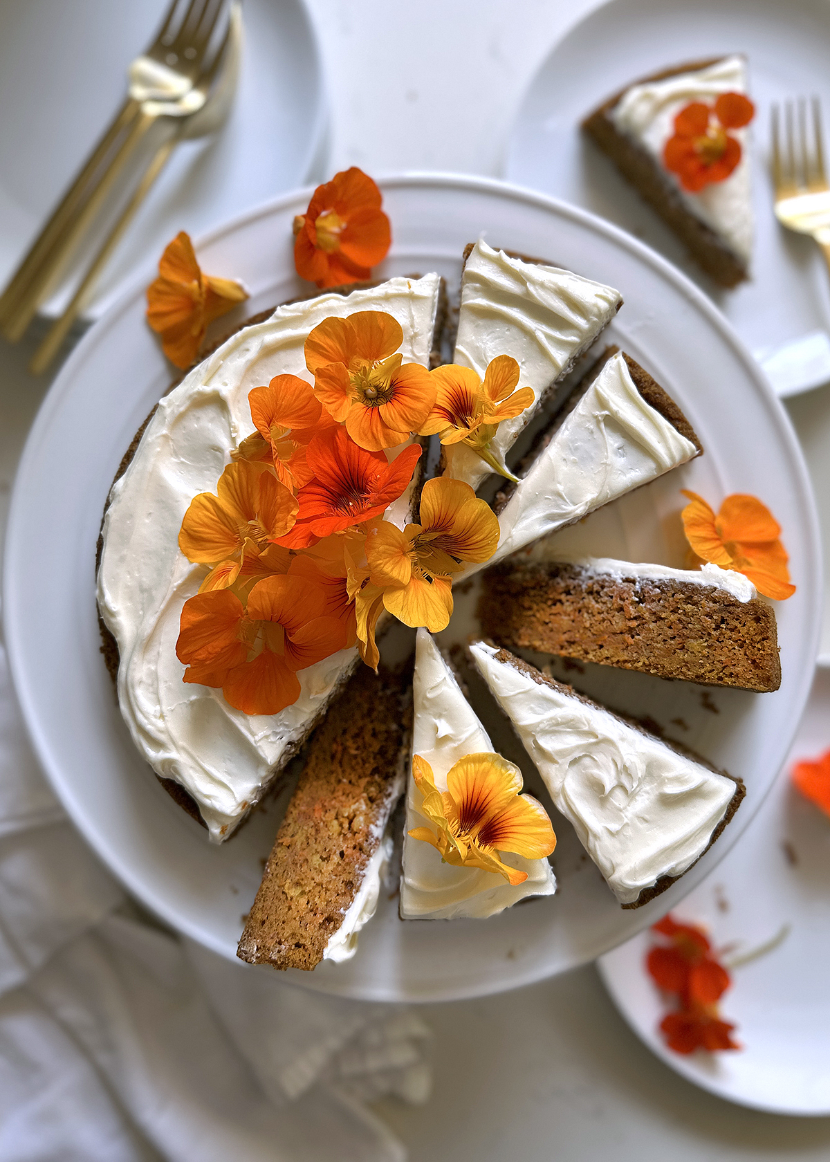 carrot cake, whole cake sliced on white cake plate