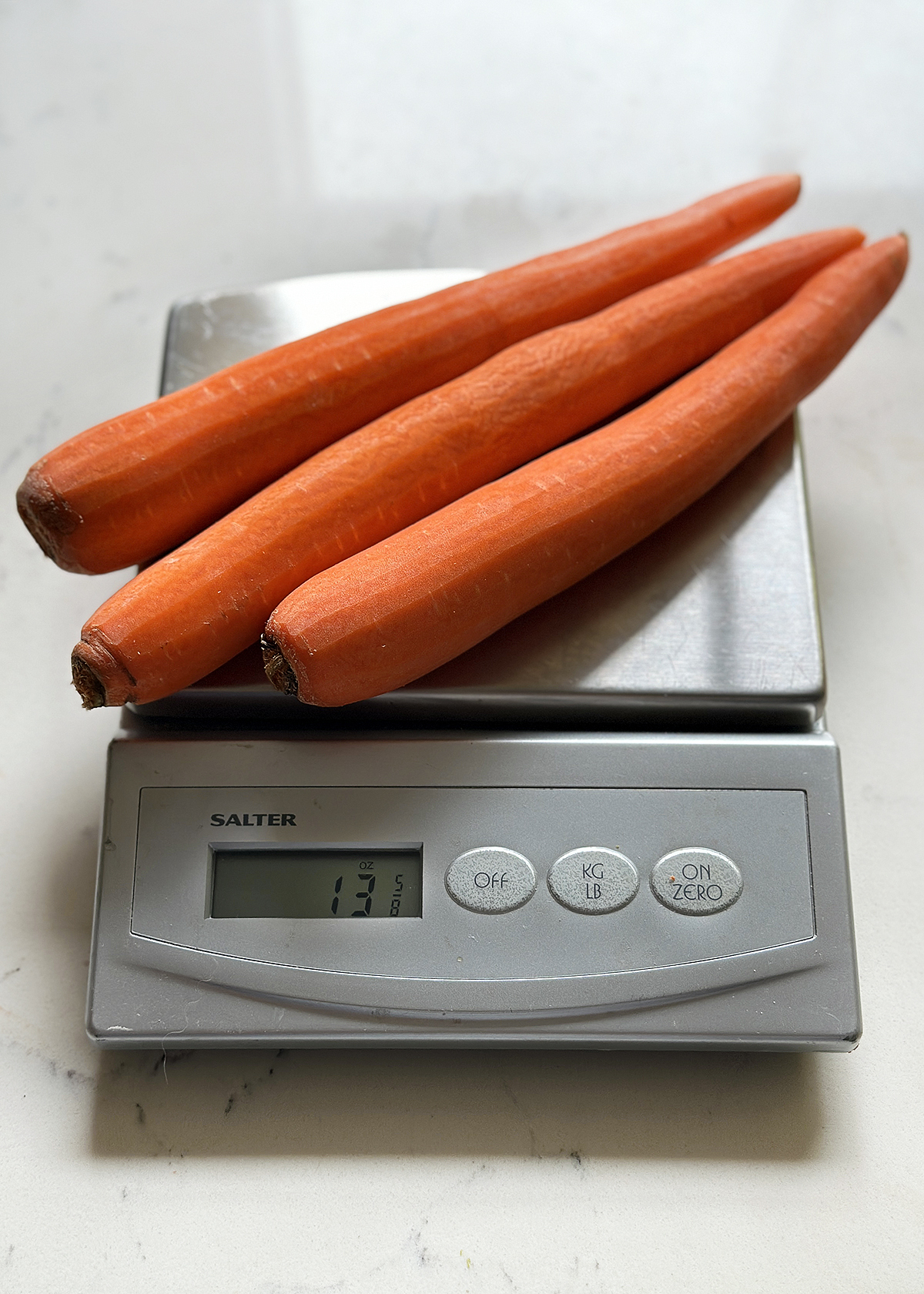 three carrots on kitchen scale