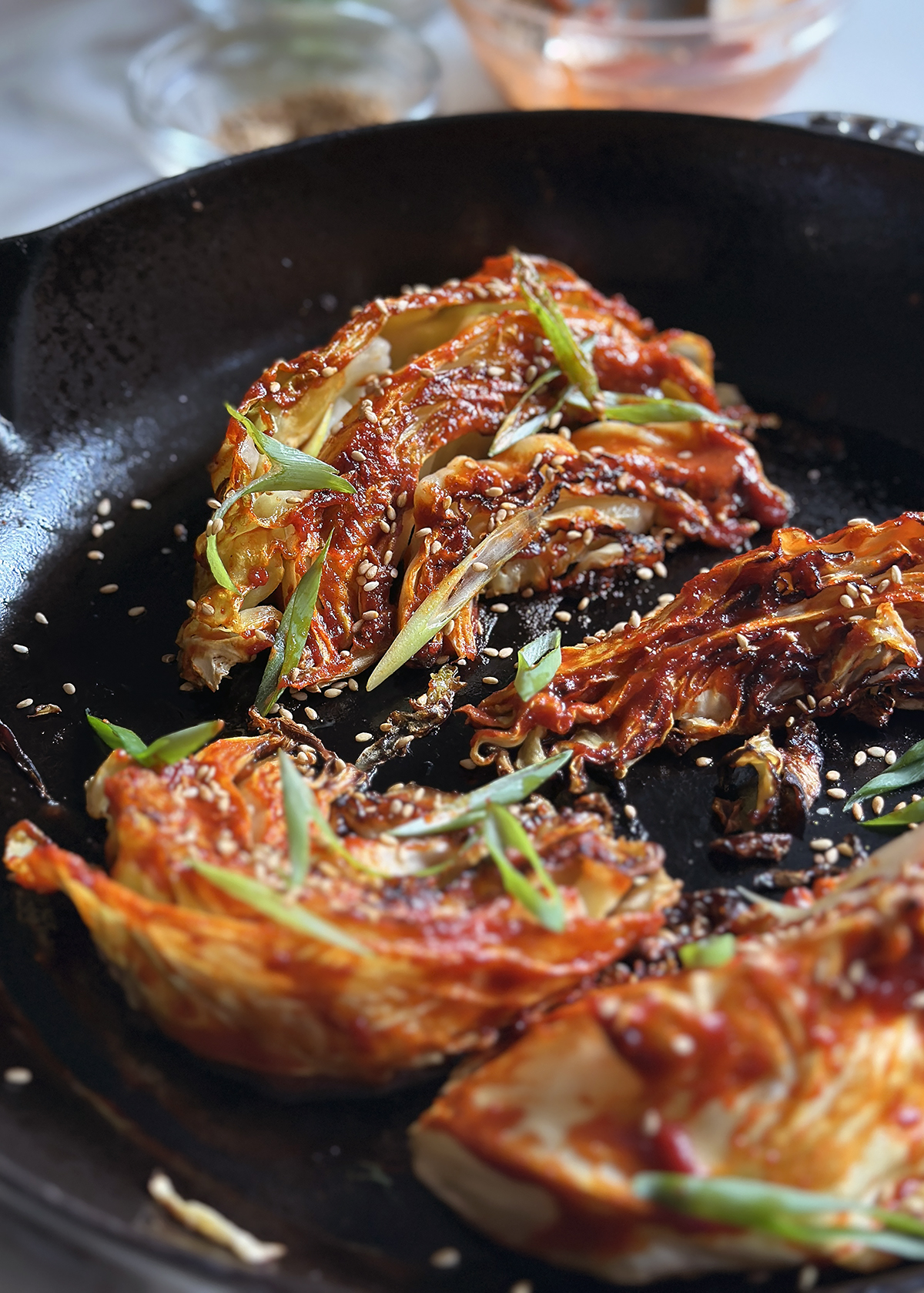 roasted cabbage with gochujang glaze in skillet, side view