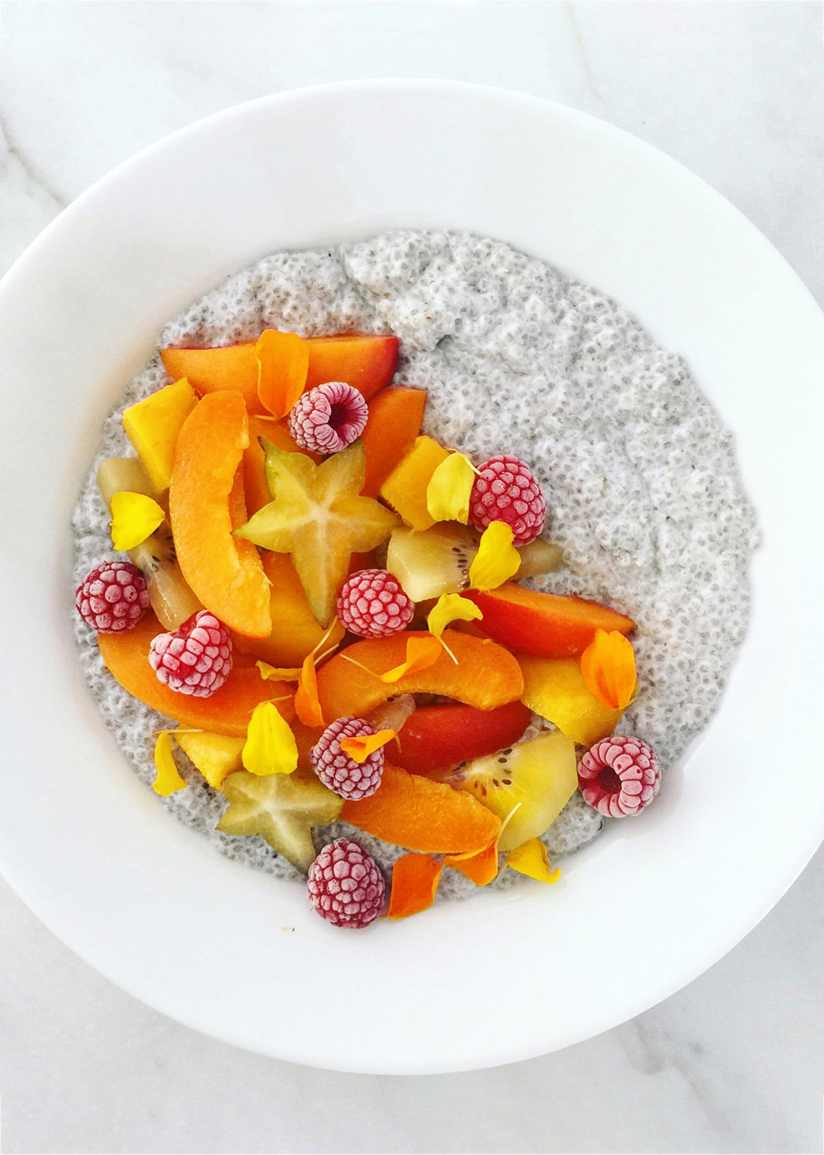 chia seed pudding with apricots raspberries starfruit and golden kiwi