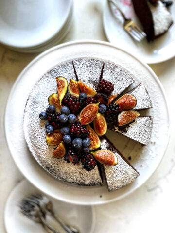 chocolate olive oil cake dusted with powdered sugar and berries on top