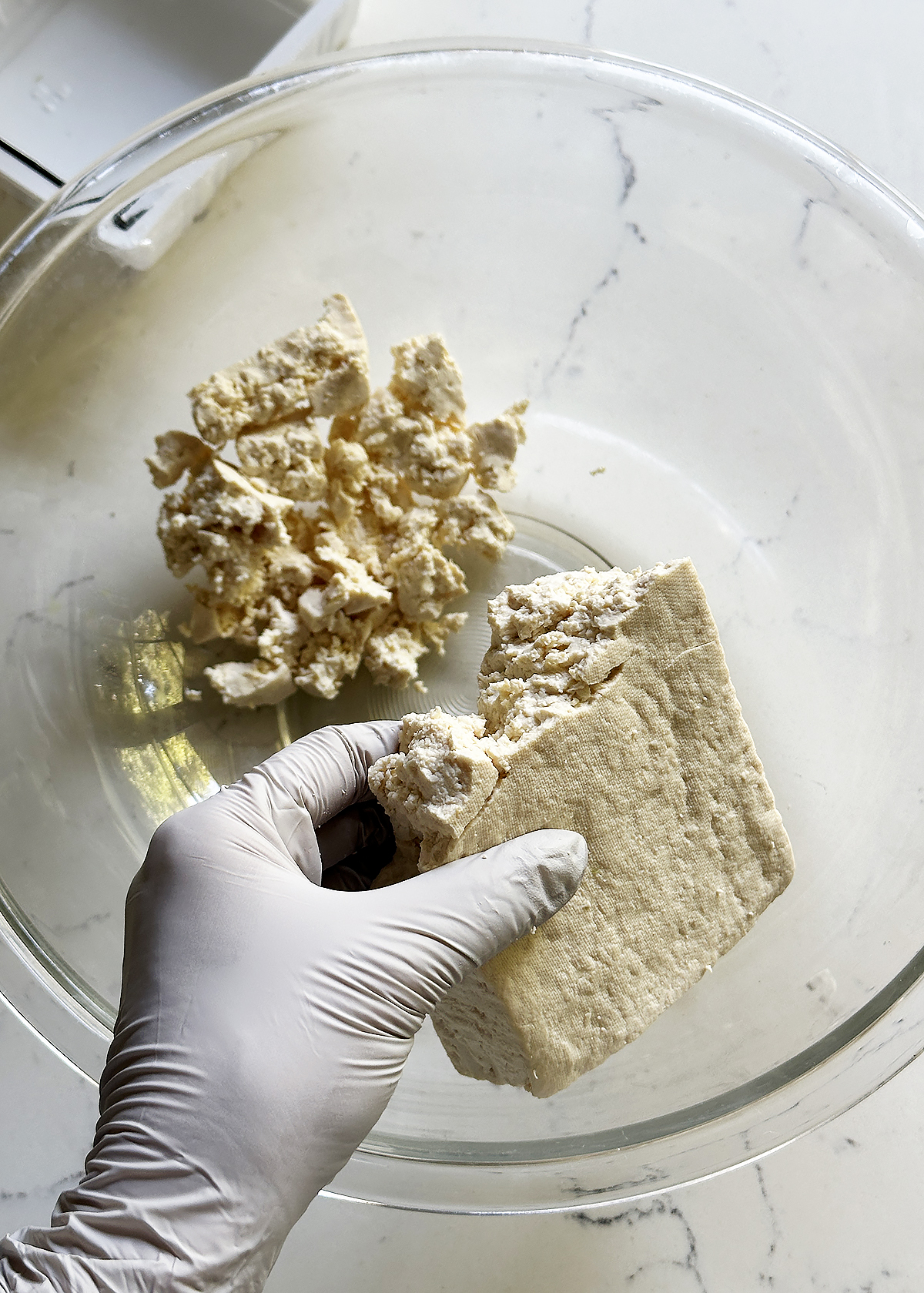 crumbling firm tofu into mixing bowl