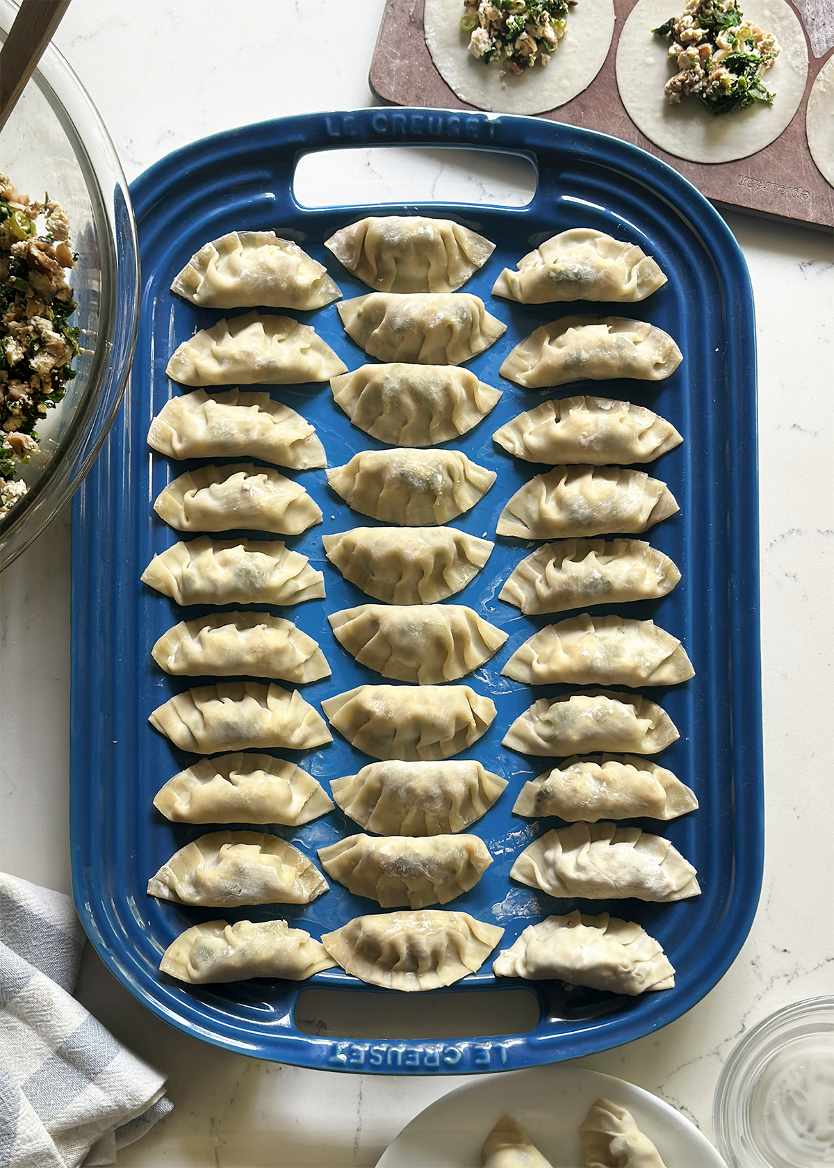 mandu korean dumplings folded on blue tray