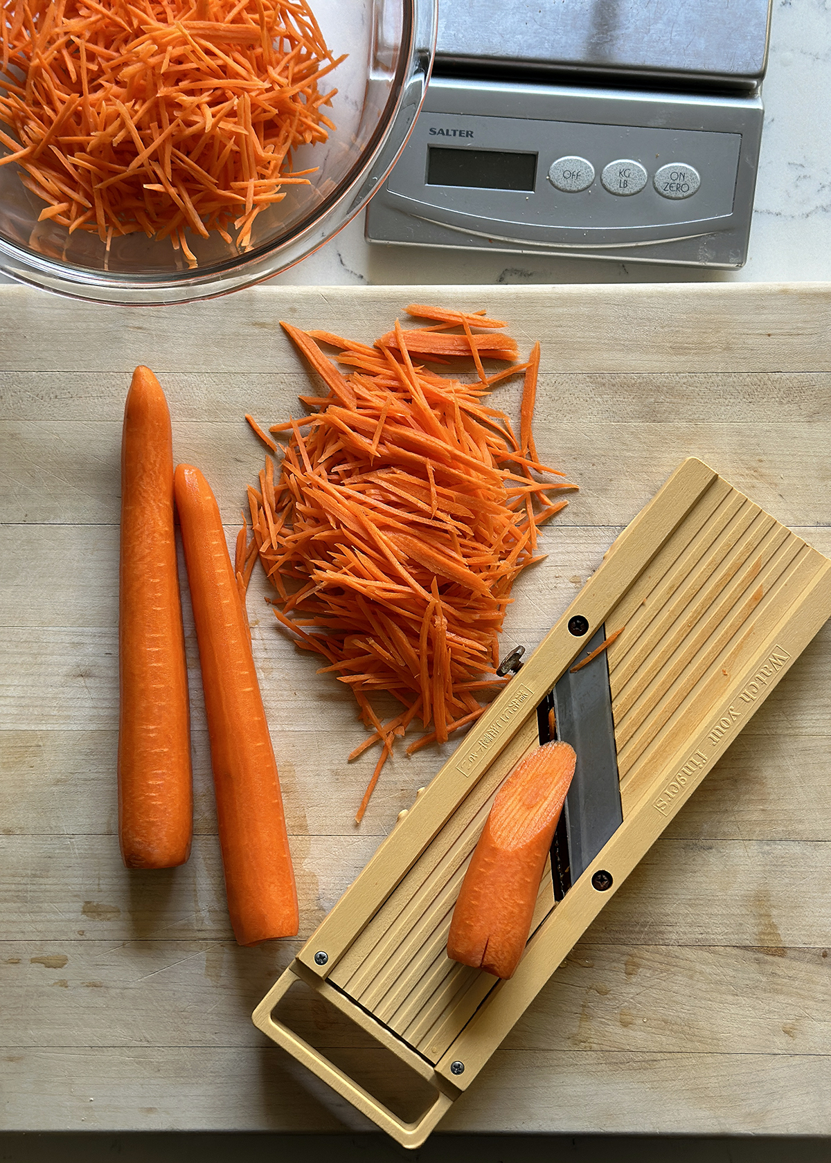 julienned carrots on cutting board with japanese mandoline