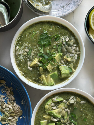 kale white bean soup in white bowls, garnished