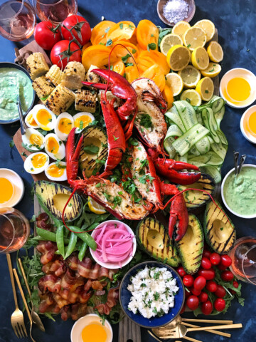 whole lobsters in shell and cobb salad on extra large wooden board