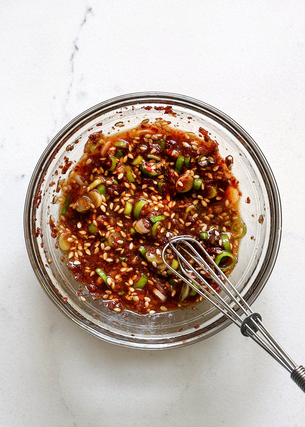 gochugaru and ingredients for oi muchim sauce in glass bowl