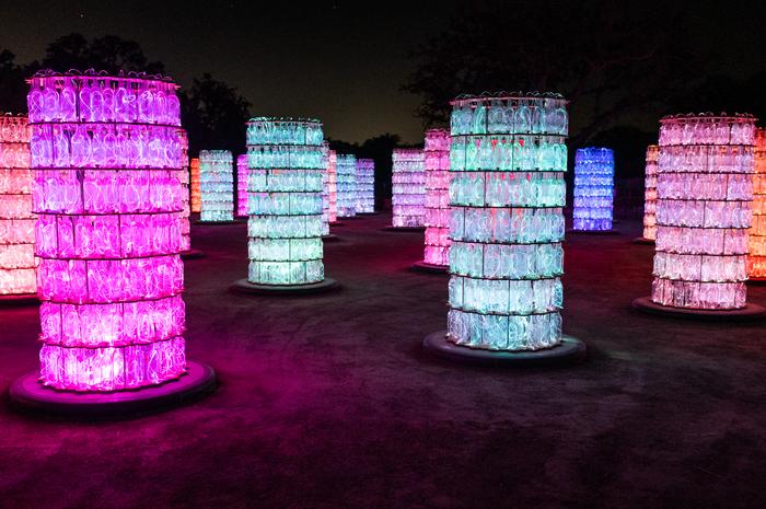 6 foot tall towers stacked with empty wine bottles filled with glowing multi-colored led lights