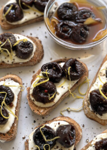pickled prunes and whipped feta on toasts on white platter