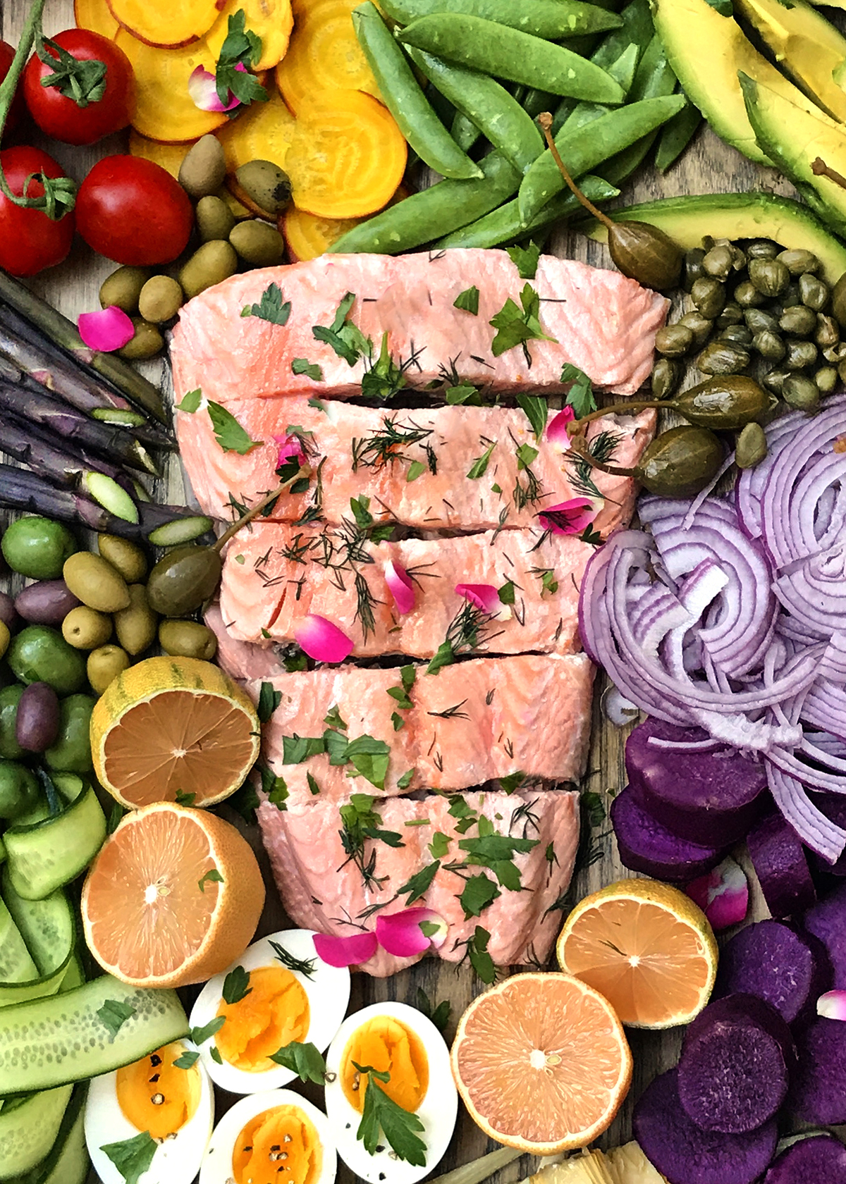 poached salmon garnished with rose herbs and rose petals with salad