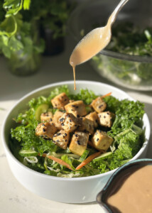 creamy sesame dressing drizzling over tofu salad