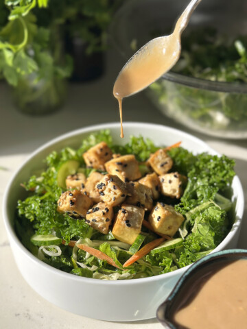 creamy sesame dressing drizzling over tofu salad