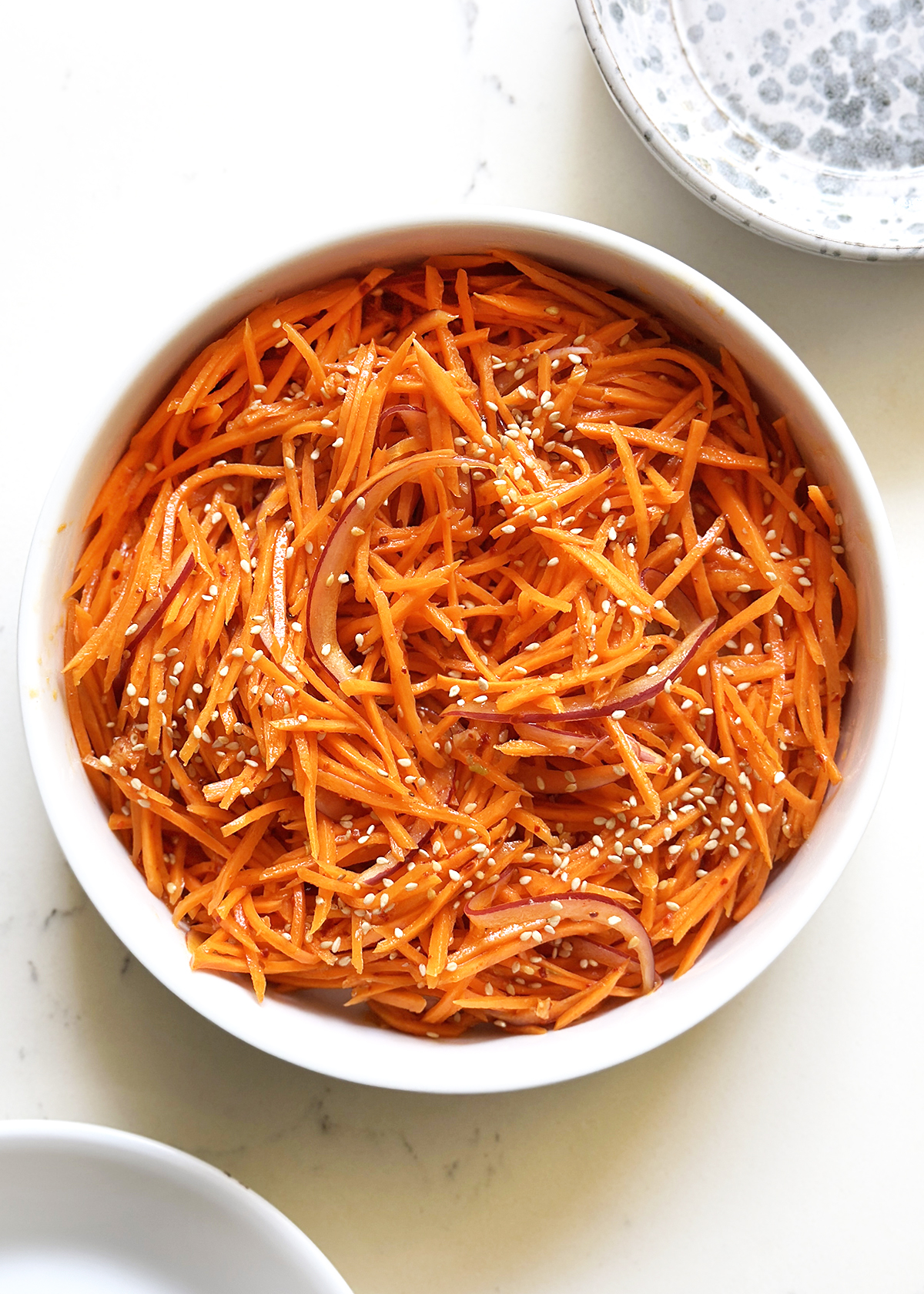 spicy carrot salad in white serving bowl